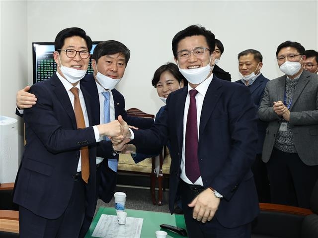 양승조(왼쪽) 충남지사와 허태정 대전시장이 지난 6일 국회에서 국가균형발전특별법이 본회의를 통과하자 손을 맞잡고 기뻐하고 있다.  대전시·충남도 제공