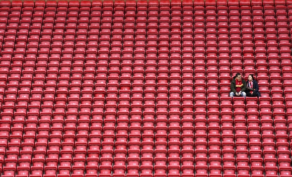 지난 7일(현지시간) 영국 리버풀의 안필드 경기장에서 프리미엄리그 축구 경기를 기다리는 두 사람 주위에 모든 좌석이 텅 비어 있다. AP통신