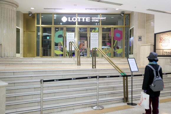 15일 부산 부산진구 롯데백화점 부산본점 입구에서 한 시민이 코로나19 관련 임시 휴점을 알리는 안내문을 보고 있다. 부산 연합뉴스