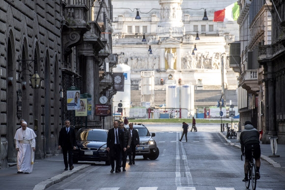 3주 만에 모습을 보인 교황이 로마 시내 거리를 걸어서 성당을 이동하고 있다.