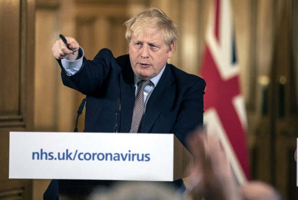 보리스 존슨 영국 총리가 16일 런던 다우닝가에서 코로나19 관련 기자회견을 열고 있다. AP 연합뉴스