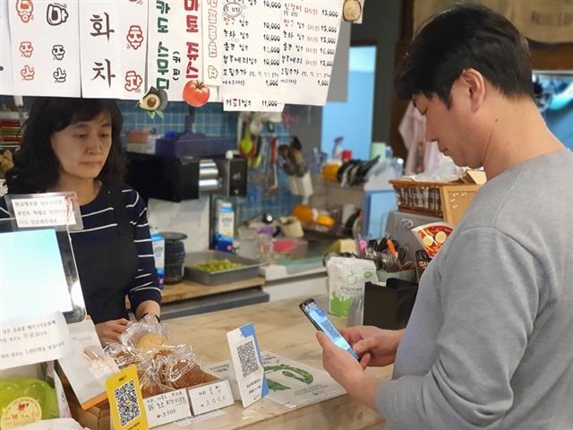 경기 성남시청 앞 커피숍에서 고객이 모바일형 성남사랑상품권으로 QR키트를 통해 결제하고 있다.
