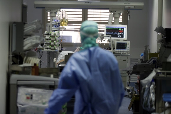 16일(현지시간) 이탈리아 롬바르디아주 브레시아의 한 병원에서 의사가 코로나19에 걸린 환자를 보고 있다. AP통신