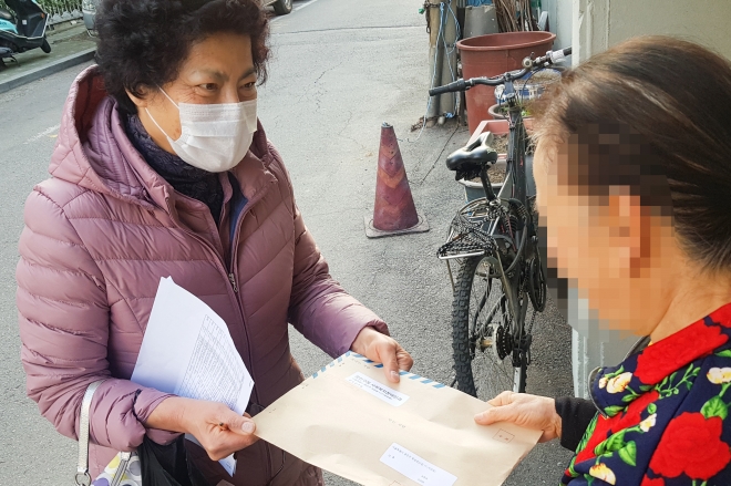 지난 18일 서울 광진구에서 통장도우미가 중증장애인 가구를 찾아 마스크를 전달하는 모습. 2020.3.20. 광진구 제공