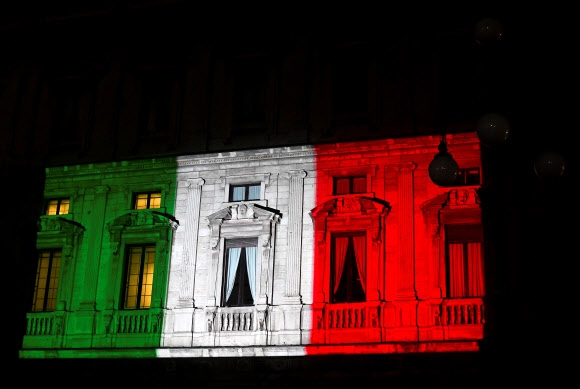 코로나19 감염증과 힘겨운 싸움을 벌이고 있는 이탈리아 밀라노의 팔라초 마리노 건물 외벽에 20일(현지시간) 이탈리아 국기가 비쳐지고 있다. 밀라노 로이터 연합뉴스 