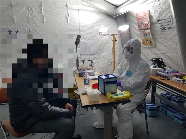 양천구의사회 소속 한 회원(오른쪽)이 지난 19일 저녁 서울 양천구보건소 선별진료소에서 코로나19 의심 환자를 진료하고 있다. 양천구 제공