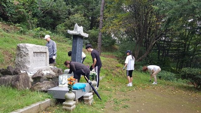 지난해 4월 출범한 ‘영원한 기억봉사단’이 결연을 맺은 묘지의 묘비를 닦고 잡풀을 제거하는 봉사활동을 하고 있다. 중랑구 제공