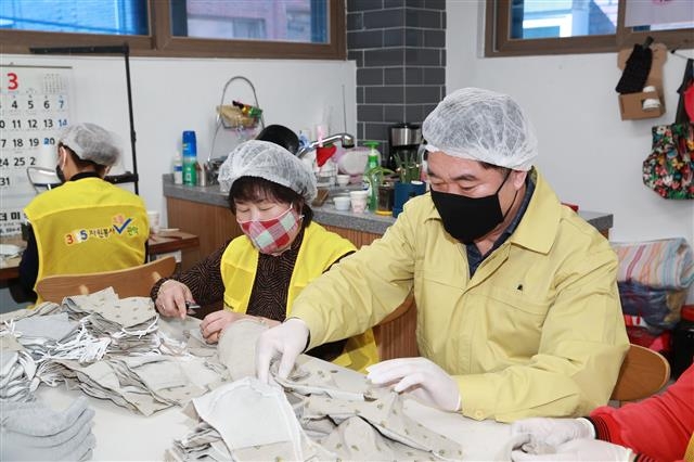 지난 18일 박준희(오른쪽) 관악구청장이 자원봉사자들과 함께 면 마스크를 만들고 있다. 관악구 제공