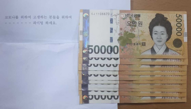 익명의 기부자가 의왕시 오전동 주민센터에 보내온 현금과 코로나19 극복을 기원하는 문구. 의왕시 제공