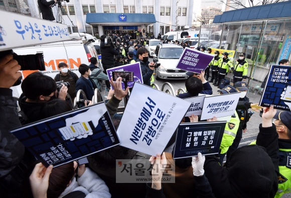 25일 인터넷 메신저 텔레그램에서 미성년자를 포함한 여성들의 성 착취물을 제작 및 유포한 혐의를 받는 ‘박사방’ 운영자 조주빈이 탄 차량이 서울 종로경찰서를 나와 검찰 유치장으로 향하자 시민들이 조주빈의 강력처벌을 촉구하며 피켓 시위를 하고 있다.  2020.3.25    박윤슬 기자 seul@seoul.co.kr