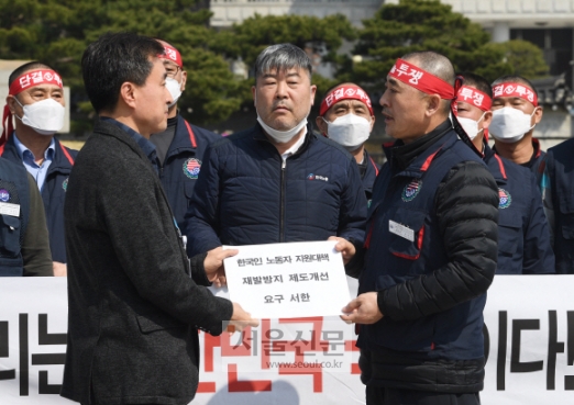 최응식 한국노총 전국외국기관노동조합연맹 전국주한미군한국인노동조합 위원장이 25일 청와대 분수대 앞에서 가진 방위비 제도개선 통한 국민 보호 촉구 기자회견에서 고영호 청와대 시민사회수석비서관실 행정관에게 ‘한국인 노동자 지원대책, 재발방지 제도개선 요구 서한’을 전달하고 있다. 2020.3.25  오장환 기자 5zzang@seoul.co.kr