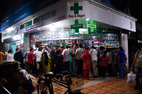 인도 뭄바이 시민들이 정부의 봉쇄령이 발효되기 직전인 지난 24일(현지시간) 마스크 등을 구매하기 위해 한 약국 앞에 몰려 있다. 뭄바이 AFP 연합뉴스