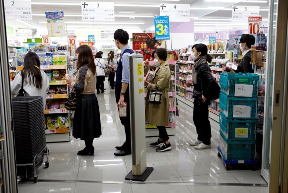 日도 마스크 구입 줄서기 일본 도쿄에서 코로나19 확진환자가 전날부터 눈에 띄게 급증하기 시작한 가운데 26일 시민들이 마스크를 사려 약국 앞에 줄을 서고 있다. 도쿄 로이터 연합뉴스