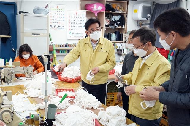 유덕열(왼쪽 두 번째) 동대문구청장이 지난달 27일 동대문구 답십리동에 위치한 봉제업체를 방문해 국민안심마스크 제작 상황을 점검하고 일손을 돕고 있다. 동대문구 제공