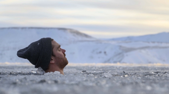 아이슬란드 수도 레이캬비크 인근의 얼음 덮인 호수에서 2월 1일(현지시간) 한 관광객이 냉찜질을 하고 있다.  AFP 연합뉴스