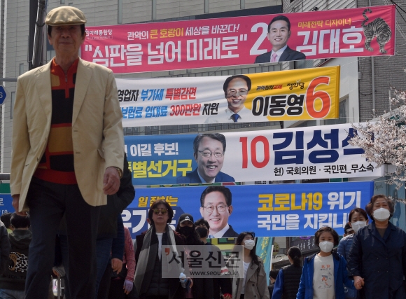 본격적인 총선 선거운동에 돌입한 2일 서울 봉천사거리에 후보들이 걸어둔 총선 후보자들의 플래카드 앞을 시민들이 지나고 있다. 2020.4.2 박지환기자 popocar@seoul.co.kr