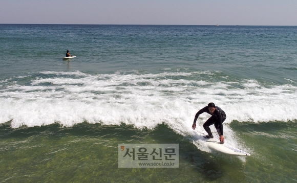 완연한 봄 날씨를 보인 6일 강원도 양양의 한 해변에서 서퍼들이 물살을 가르며 서핑보드를 즐기고 있다. 2020.4.6 박지환기자 popocar@seoul.co.kr