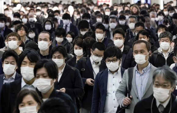 거의 모두가 마스크를 쓴 일본 도쿄의 직장인들이 6일 중심부의 한 기차역을 빠져나와 직장을 향해 발걸음을 옮기고 있다. 도쿄 EPA 연합뉴스 