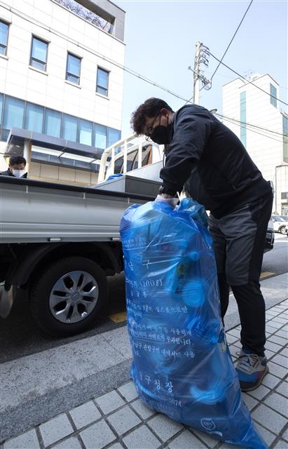 최유성 서울 강남구 청소행정과 주무관이 지난 6일 관내 자가격리 해제자의 집에서 50ℓ짜리 봉투를 가득 채운 쓰레기 더미를 갖고 나와 용달차에 싣고 있다. 강남구 제공