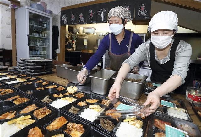 지난달 16일 서울 광화문 이마빌딩의 한 식당 직원들이 KT 구내식당에 배달할 ‘사랑 나눔 도시락’을 정성스레 준비하고 있다.  KT 제공
