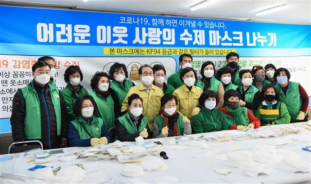 오거돈(가운데) 부산시장이 최근 수제 면마스크를 직접 만들어 취약계층에 써달라고 기탁한 새마을부녀회 회원들을 격려하고 기념촬영을 하고 있다. 부산시 제공