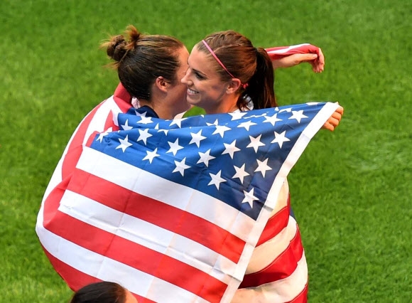 미국 여자축구 대표팀 선수들이 지난 2015년 7월 캐나다 여자 월드컵 결승전에서 일본을 5-2로 꺾고 우승을 차지한 뒤 성조기를 두르며 기뻐하고 있다. 미국 여자 대표팀은 2019년 프랑스 대회에서도 정상에 오르는 등 여자 월드컵 통산 4회 우승을 자랑하는 최강 팀이다. AFP 연합뉴스