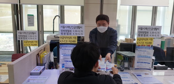 지난 9일 서울 강북구 미아동 주민센터에서 한 주민이 보건용 마스크를 지급받고 있다. 2020.4.10. 강북구 제공