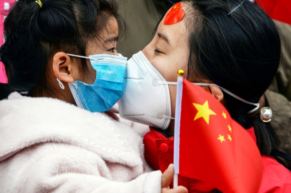 우한에서 집으로 돌아온 한 의료진이 10일(현지시간) 중국 동부 안후이성 보저우에서 딸에게 키스하고 있다. AFP 연합뉴스