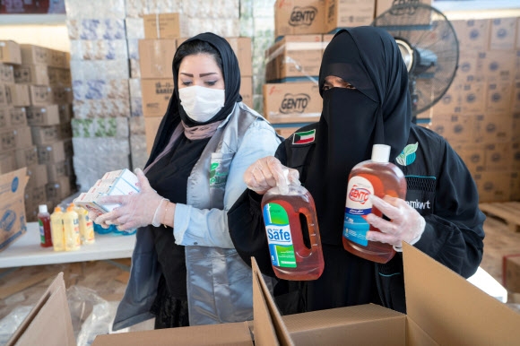 쿠웨이트의 자원봉사자들이 마스크를 쓴 채 4일(현지시간) 빈곤층에게 나눠줄 생필품을 상자에 담고 있다. 2020.4.7  로이터 연합뉴스