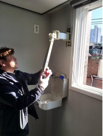 서울 마포구 관계자가 13일 성산동의 한 다가구주택에서 화재 피난구조설비인 완강기를 설치하고 있다. 마포구 제공