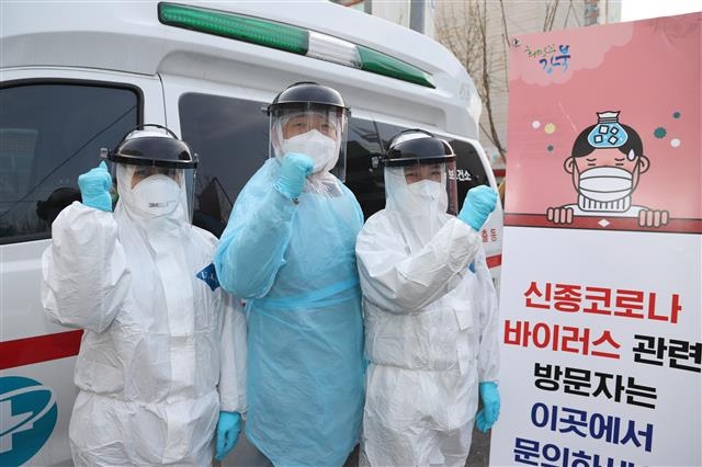 서울 강북구 코로나19 전담 방역요원과 구보건소 관계자들이 지난 6일 보건소 선별진료소 앞에서 방호복을 입고 파이팅을 외치고 있다. 강북구 제공