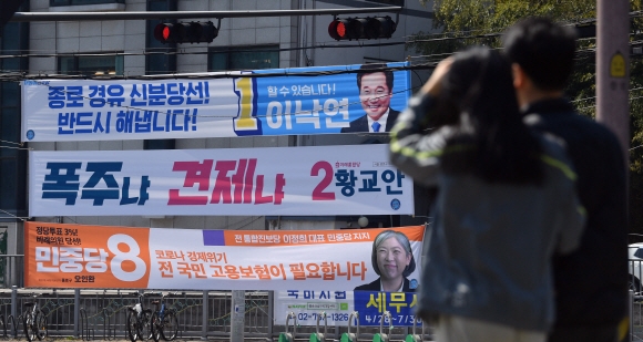 제21대 국회의원 선거를 하루 앞둔 오후 14일 서울 세검정로에 붙어있는 선거현수막을 시민들이 살펴보고 있다. 2020.4.14 박지환기자 popocar@seoul.co.kr