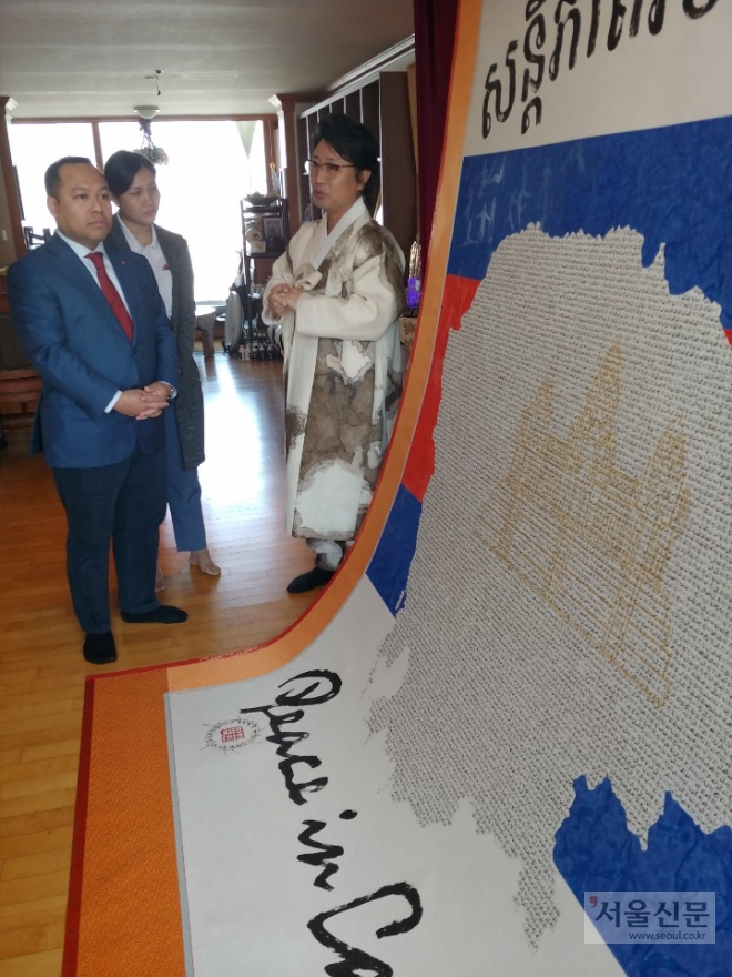 한한국(오른쪽) 세계평화작가가 롱 디망시 주한 캄보디아 대사에게 캄보디아 평화지도 Cambodia Peace Map 작품에 대해 설명하고 있다.