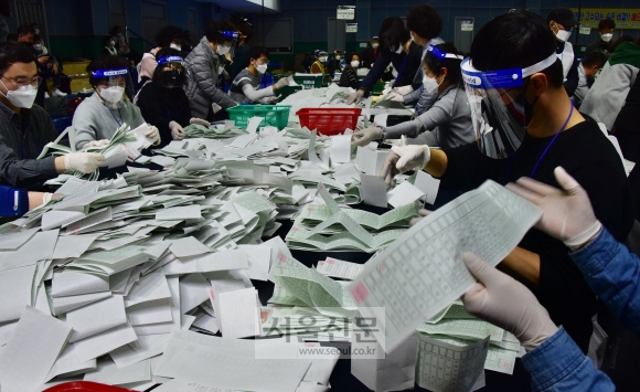 15일 제21대 국회의원 선거의 투표가 끝나자 영등포구선관위 개표소인 영등포다목적배드민턴체육관에서 각 투표소별로 수거해온 투표용지를 개표요원들이 검수 및 확인을 하며 개표작업을 하고 있다. 특히 이번에는 비례대표 출마 정당이 많아서 일일이 수작업을 거쳐야만 했다. 2020.4.15.     이종원 선임기자 jongwon@seoul.co.kr