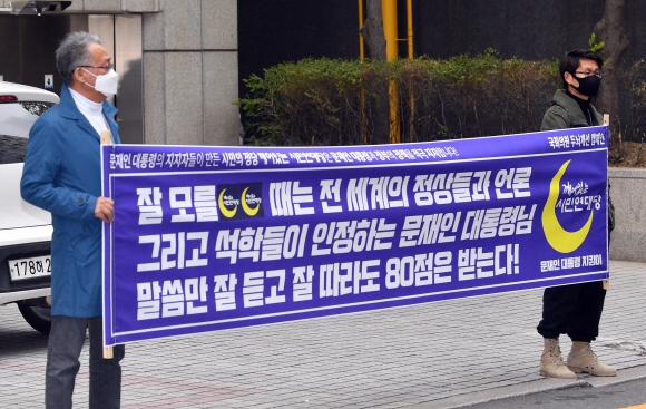 20일 서울 영등포구 여의도 민주당사 앞에서 깨어있는 시민연대당 소속 회원들이 문재인 대통령의 정책운용을 지지하는 피켓을 들고 서 있다. 2020.4.20 박지환기자 popocar@seoul.co.kr