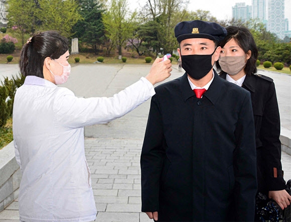 북한 대외선전매체 내나라는 20일 각급 대학과 고급중학교(고등학교)에서 학생들이 수업을 시작했다고 밝혔다. 등교길 교문에서 체온 측정을 받고 있는 북한 학생들의 모습. 2020.4.20  내나라 웹사이트 캡처