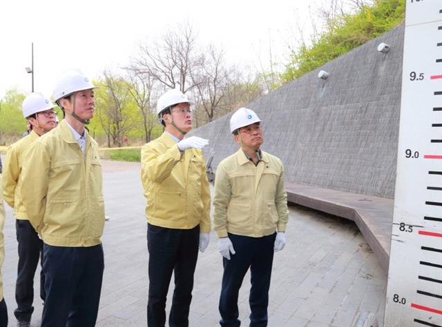 채현일(오른쪽 두 번째) 영등포구청장이 지난해 4월 18일 당산 나들목 육갑문 시운전 현장에서 수위표를 살피고 있다. 영등포구 제공