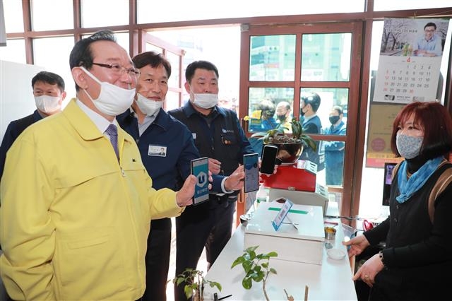 송철호(왼쪽) 울산시장과 하언태(가운데) 현대차 사장, 이상수(오른쪽) 현대차 노조지부장이 22일 울산 북구 명촌동 한 음식점에서 돼지국밥을 먹은 뒤 울산페이로 결제하고 있다. 울산시 제공