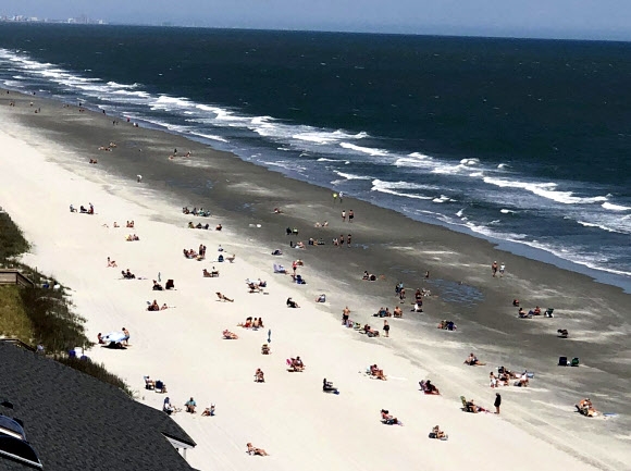 지난 21일 (현지시간) 재개장한 미국 사우스캐롤라이나 머틀비치에서 시민들이 바다를 즐기고 있다. AP통신
