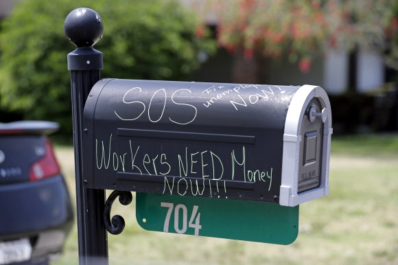 지난 13일(현지시간) 미국 플로리다주의 한 주택 우체통에 ‘실직자는 돈이 필요하다’는 호소가 씌여 있다. AP통신