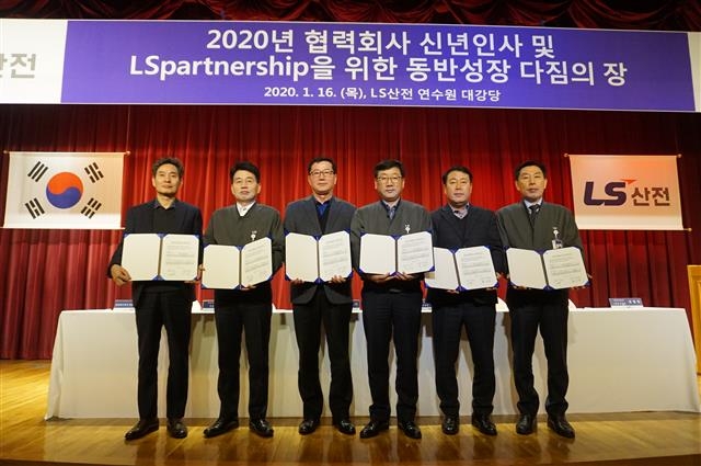 LS일렉트릭의 충남 천안사업장 공장장과 협력사 대표들이 지난 1월 청주 연수원에서 ‘2020년 신년인사 및 동반성장 다짐의 장’ 행사가 끝난 뒤 협약서를 들어 보이고 있다. LS그룹 제공