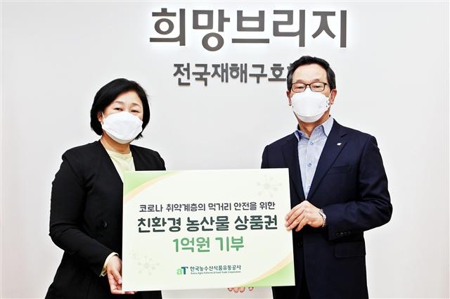 이병호(오른쪽) 한국농수산식품유통공사(aT) 사장이 지난 16일 임원 월급을 반납해 마련한 친환경 농산물 상품권을 김정희 재해구호협회 사무총장에게 전달하고 있다. 한국농수산식품유통공사 제공