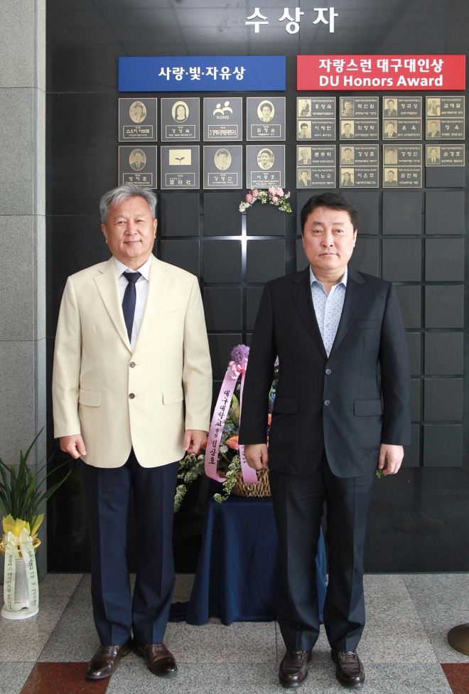 . 서중호(오른쪽) 대표이사가 대구대학교 명예의 전당 앞에서 김상호 대구대 총장과 함께 사랑·빛·자유상 수상 기념 사진을 찍고 있다.(