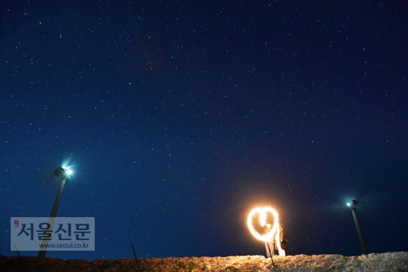 강릉 안반데기를 찾은 한 젊은 커플이 밤하늘에 떠 있는 별을 배경으로 기념사진을 찍고 있다. 예전 안반데기는 낮에 고랭지 배추밭 풍경을 보는 곳이었지만 요즘은 별과 함께 ‘인생사진’을 찍으려는 젊은이들이 즐겨 찾는 밤의 명소가 됐다.
