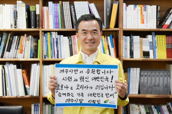 이항진 시장은 ‘여주시민이 응원합니다. 시련과 혁신의 대한민국! 코로나는 코리아가 이깁니다. 함께 하는 가족 대한민국 만세’라고 직접 쓴 문구를 들고 반드시 코로나19 극복을 위한 응원을 하고 있다.          여주시청 제공. 