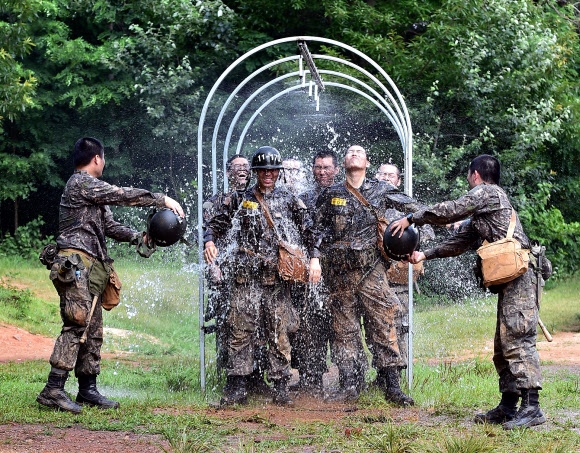 8일 충남 논산 육군훈련소에서 훈련을 마친 훈련병들이 샤워터널을 지나며 더위를 식히고 있다. 2019.8.8 육군훈련소 제공