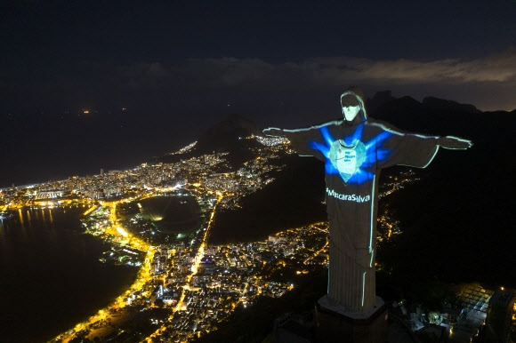 3일(현지시간) 브라질 리우데자네이루 예수상에 코로나19 확산 방지를 위한 마스크 착용 권고 메시지가 투사되고 있다. AP 연합뉴스