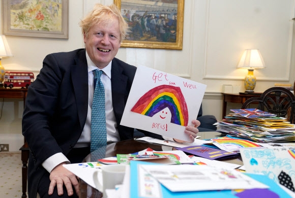 보리스 존슨 영국 총리가 지난 28일 한 어린이로부터 받은 쾌유 기원 카드를 들어보이고 있다. 연합뉴스 