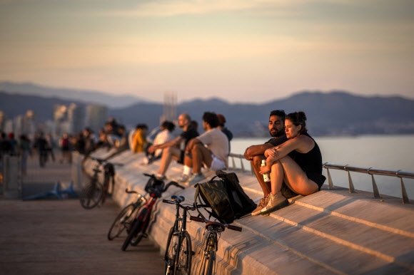스페인의 성인에게도 야외 운동이 허용된 첫날인 3일(현지시간) 바르셀로나 시민들이 제방 위에 앉아 일몰을 즐기고 있다. 바르셀로나 AP 연합뉴스 