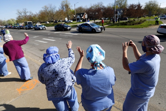 미국 디트로이트에서 의료진들이 4일 감사를 표하는 지역사회의 차량 행렬에 답례하기 위해 병원 밖에서 손을 흔들고 있다. 연합뉴스